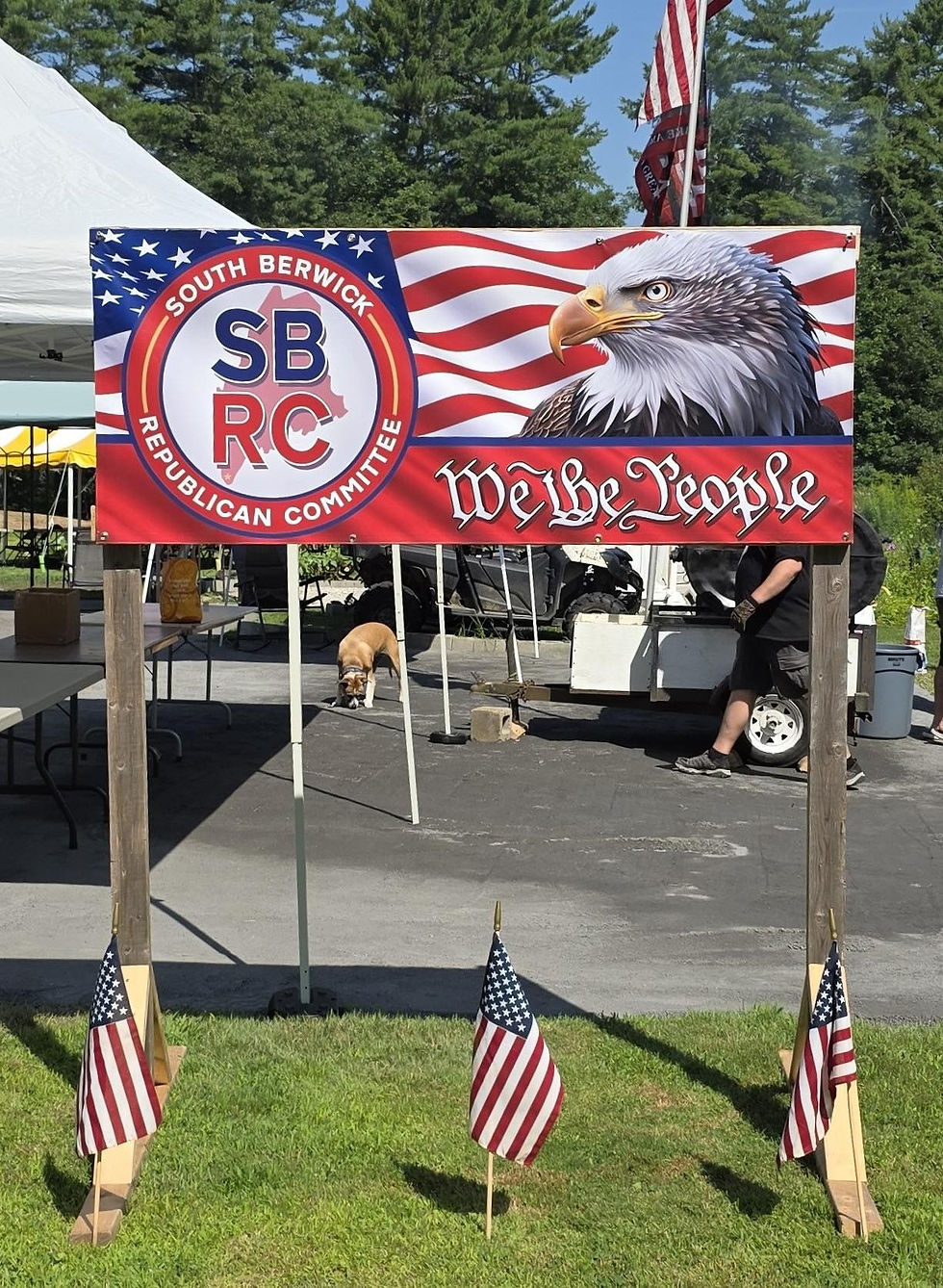 Outdoor South Berwick Republican Committee event banner mounted on wooden posts with American flags