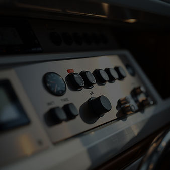 “close-up of brushed metal and controls inside a yacht system panel, soft light, shallow d
