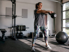 Woman performing kettlebell swing in home gym