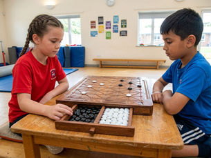 Deux enfants, en rouge et bleu, jouent à un jeu de fanorona en bois dans une salle de sport, concentrés.