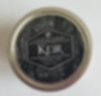 A black candle. the middle text says "Keir". The bottom text says "Woodlands" and "Rose"