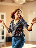 Woman in jeans dancing in her living room.
