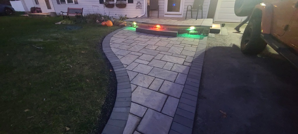 Gray paver walkway and lighted steps at night