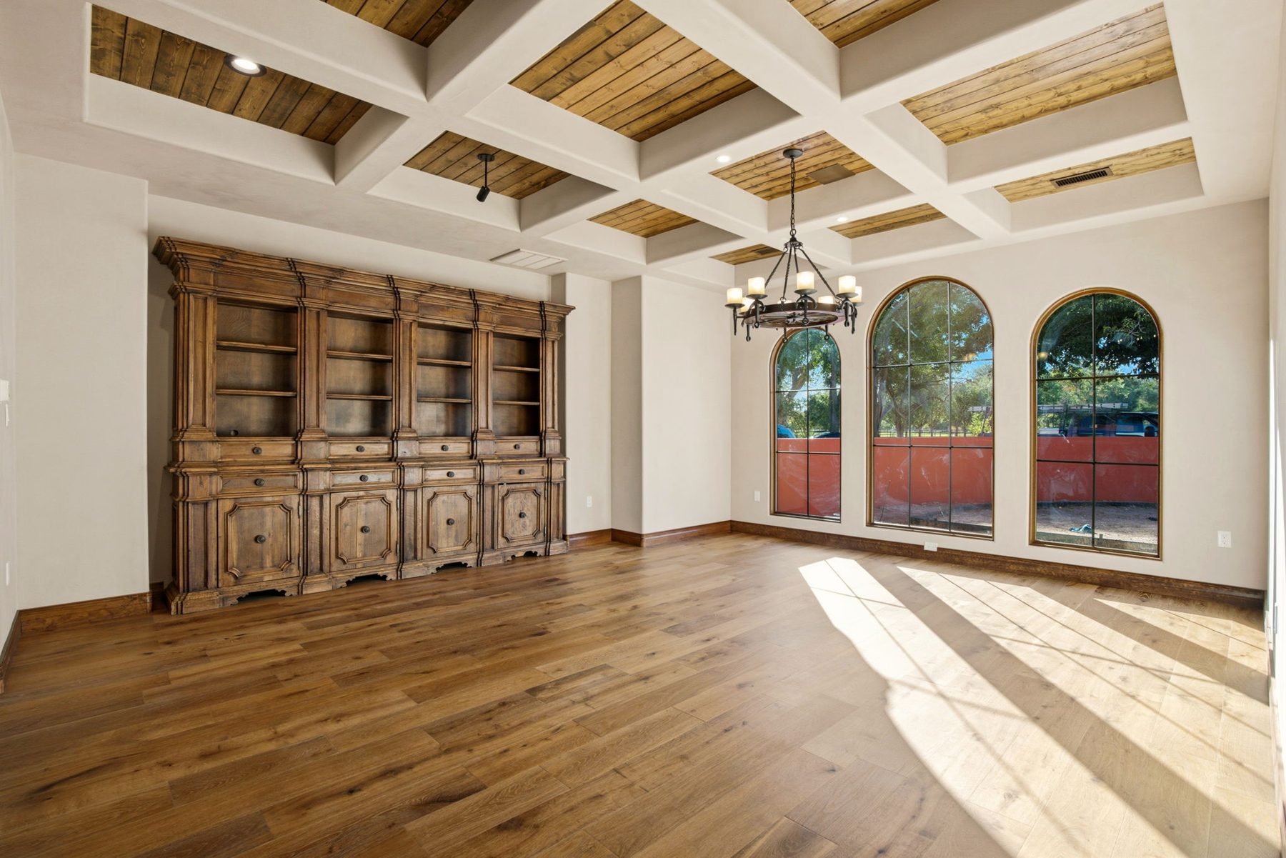 Coffered ceiling dining room with arched windows