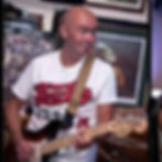 Man playing electric guitar, wearing a Pepsi shirt