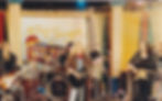 Band on stage with guitars, drums, 'Sing & Smile' backdrop