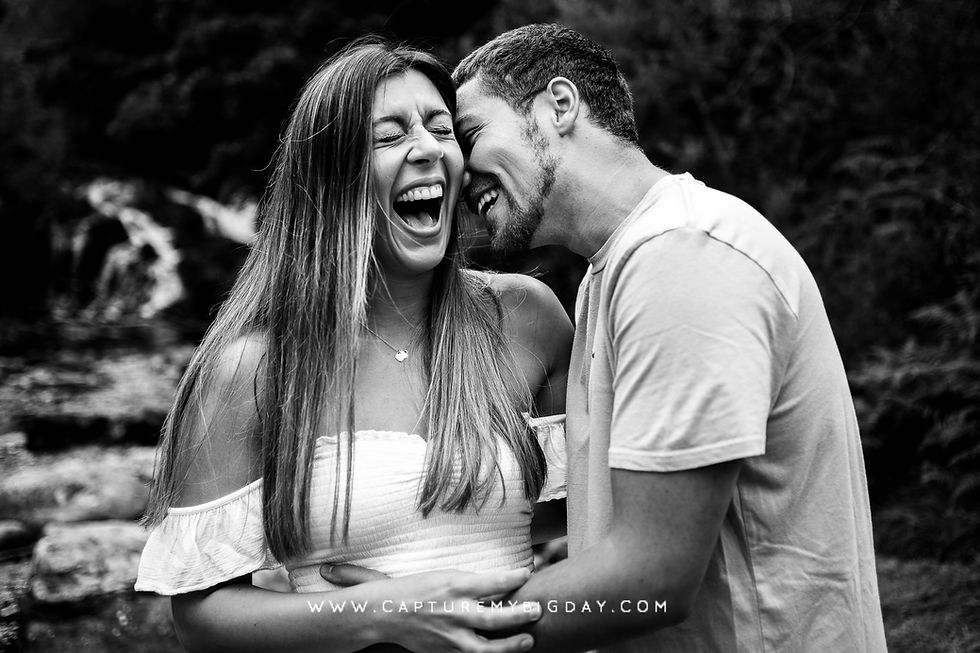 Engaged couple laughing in black and white