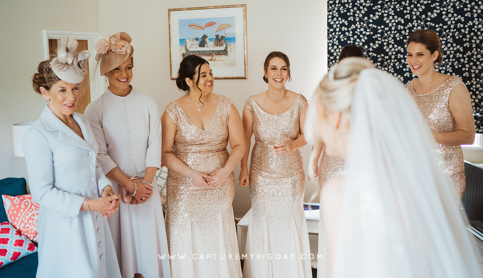 Bride revealing her dress to Bridesmaids