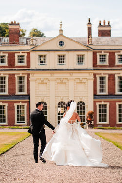 Bride and groom walking to Hall