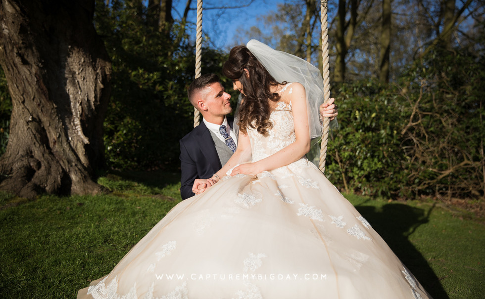 bride sitting on groom on swing