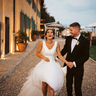 Bride and groom walking and laughing in Tuscany