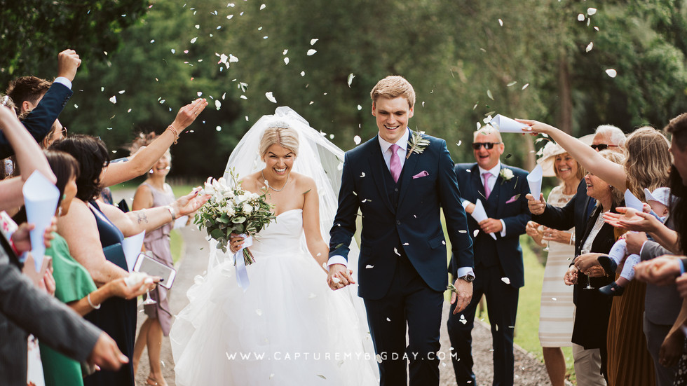 bride and groom walking through confetti