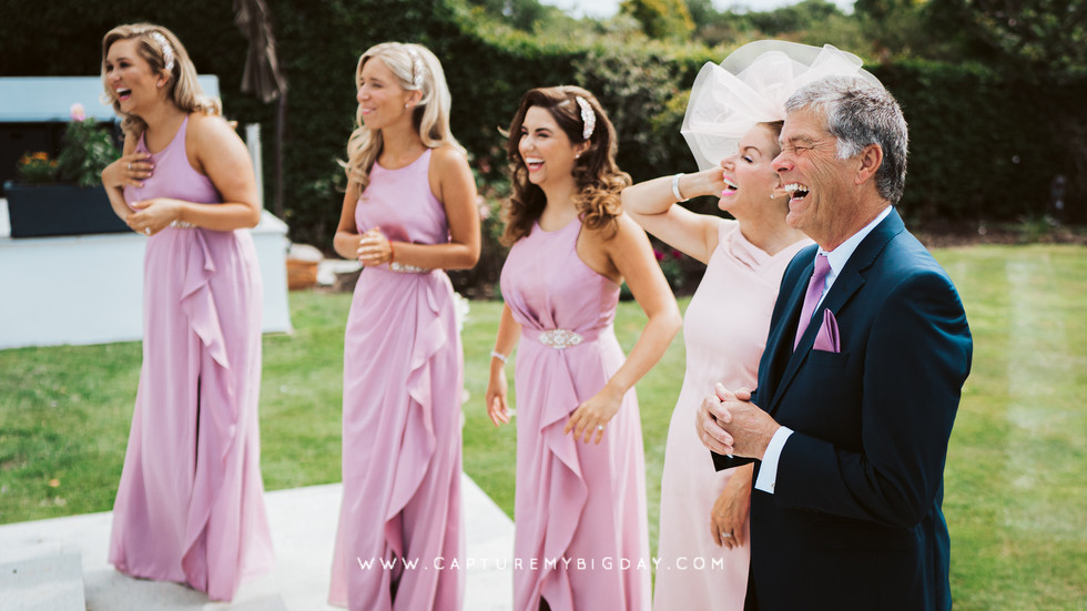 Bridesmaids with brides parents laughing