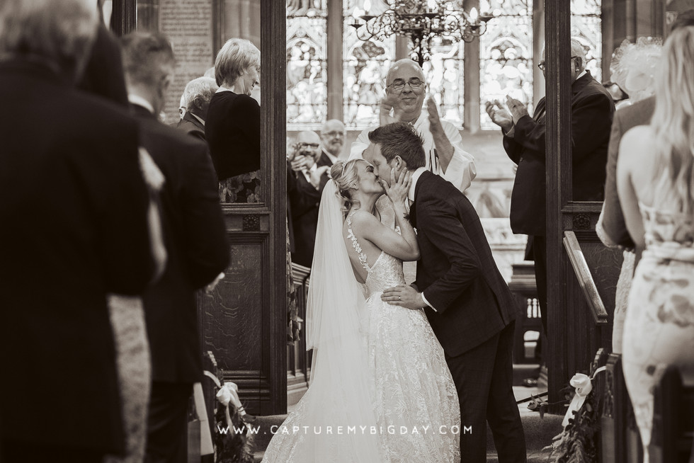 bride and groom kissing in church