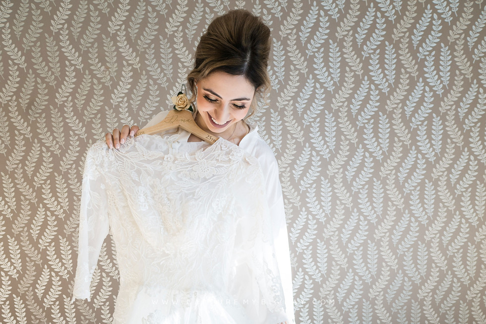 Bride holding wedding dress