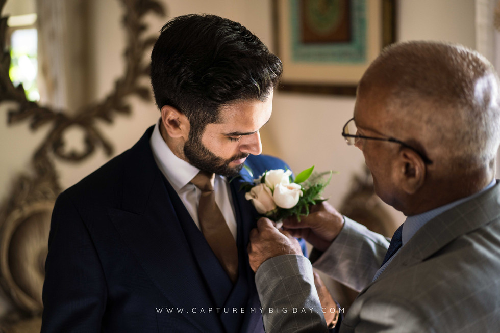 groom having flowers pinned to his jacket