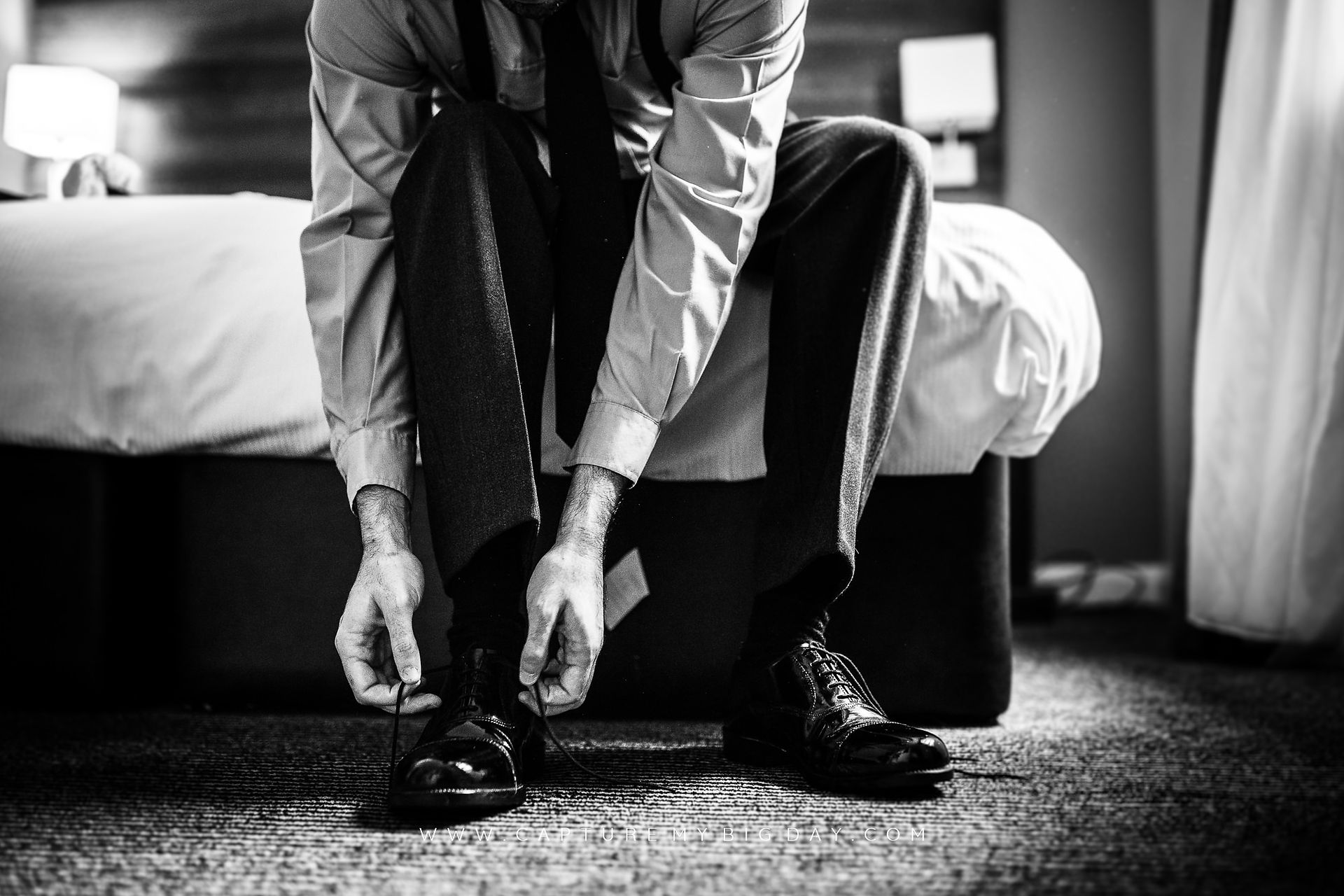 groom putting his shoes on