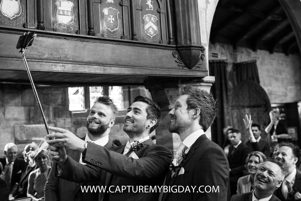 groom taking selfie in church