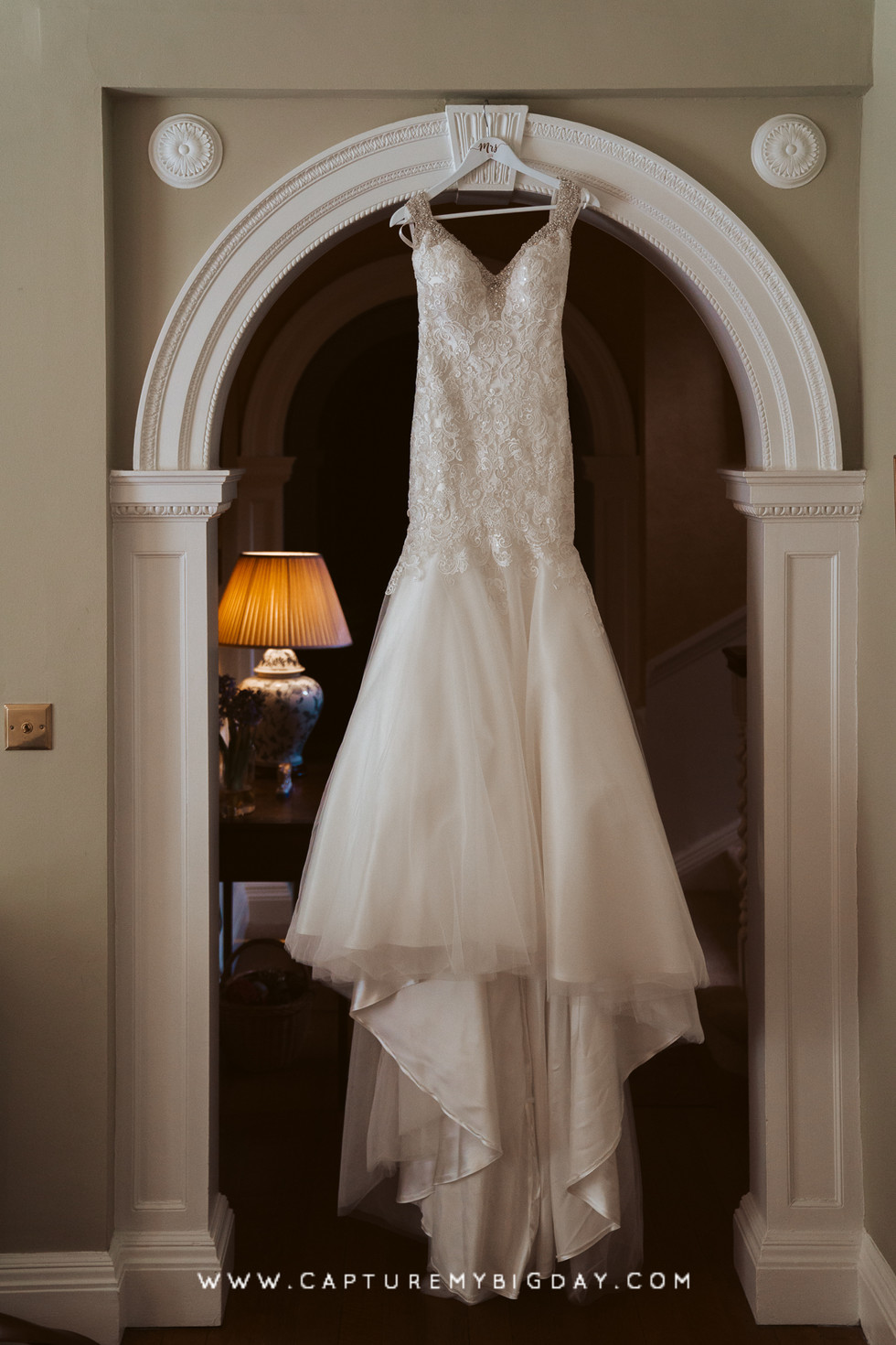 Wedding dress hanging in doorway