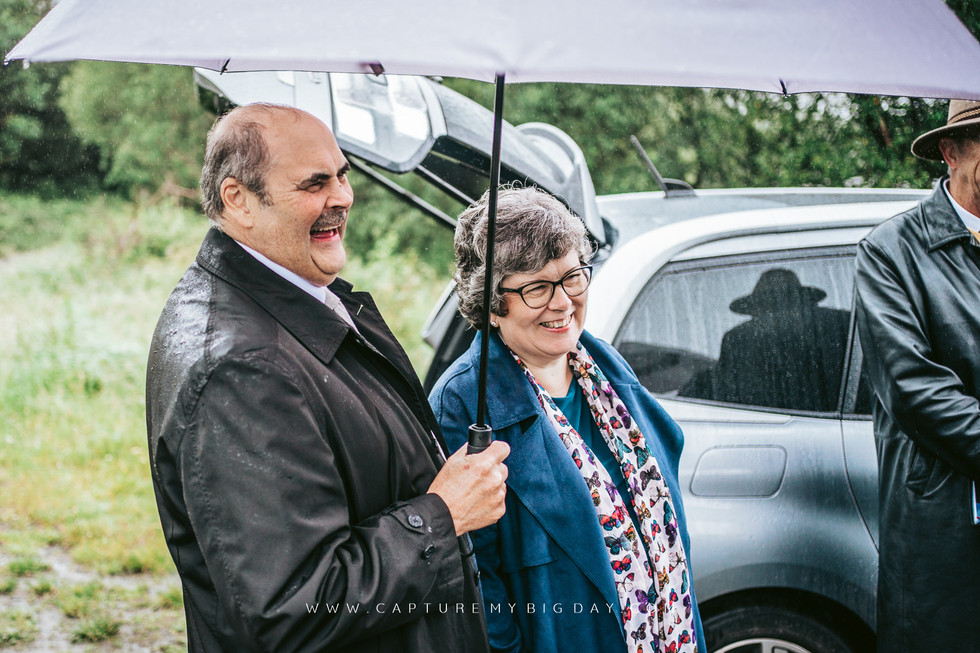 parents laughing under umbrella