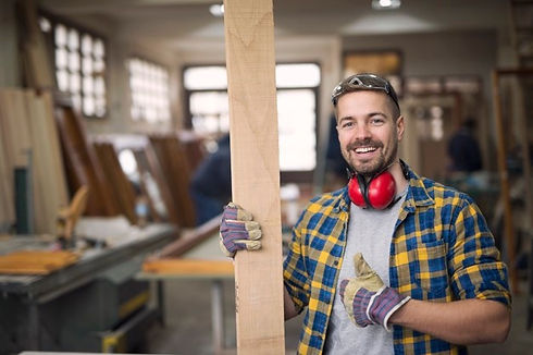 portrait-handsome-smiling-carpenter-with-wood-material-workshop-holding-thumbs-up_342744-8