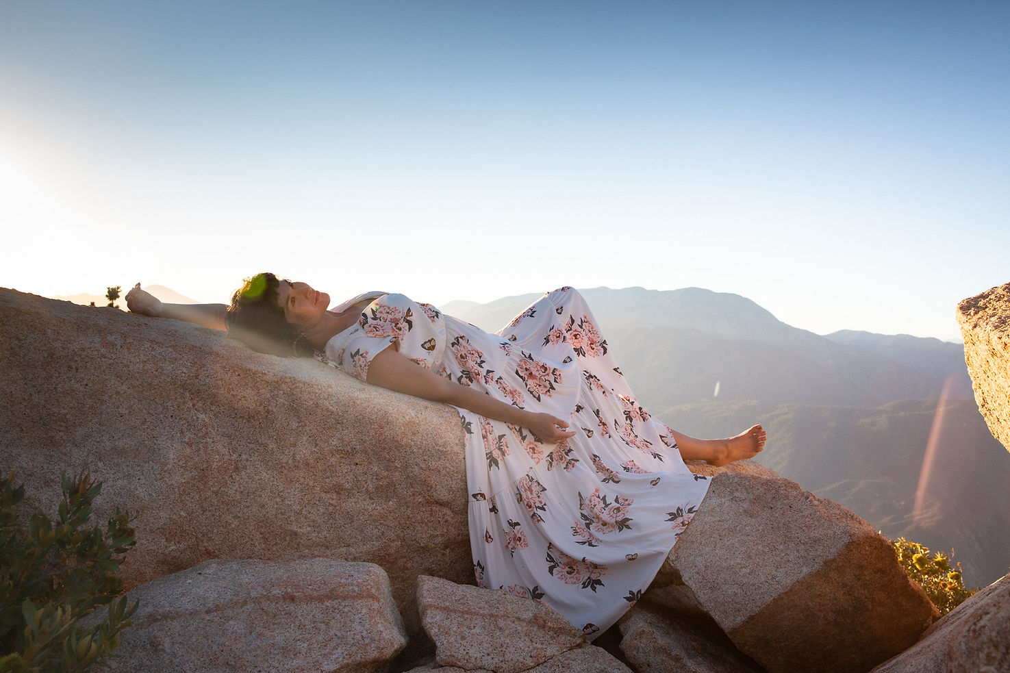 aimee tekaya somatic heart led leader laying on a rock in the mountains.jpeg