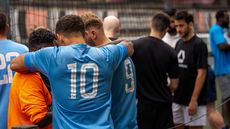 Charity football team huddle and celebrate their hard work.