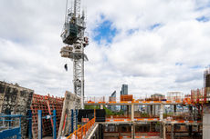 The Fire Service conducts a crane cabin rescue drill above an active construction site in North London, with a fireman seen rappelling down with a dummy patient.