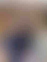 Family standing in front of the Denali National Park & Preserve wooden entrance sign, surrounded by trees and mountain scenery