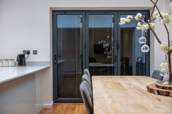 Floor-to-ceiling bifold door installation in contemporary kitchen