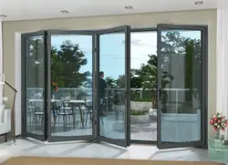 Aluminium bifolding doors opening onto patio with garden view