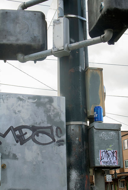 street light post with minor graffiti and a soda can pirched on top of a metal box