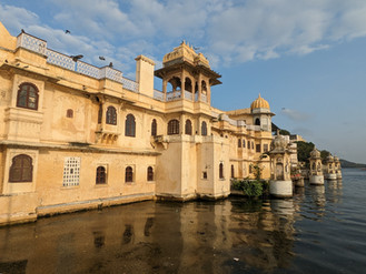 View of a sand coloured palace-like building on the edge of Lake Pichola, making it one of the attractions you should visit in Udaipur, India