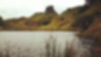 Strange castle-like outcrop of stone with unusual bumpy landscape and a small pond making the Fairy Glen one of the best things to see and do in Skye