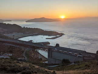Small harbour and bridge in the foreground with a small island and the sun rise in the background enjoyed during a family day out in Marin County