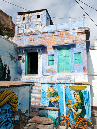 Street art murals on the side of a wall, women in a domestic setting.