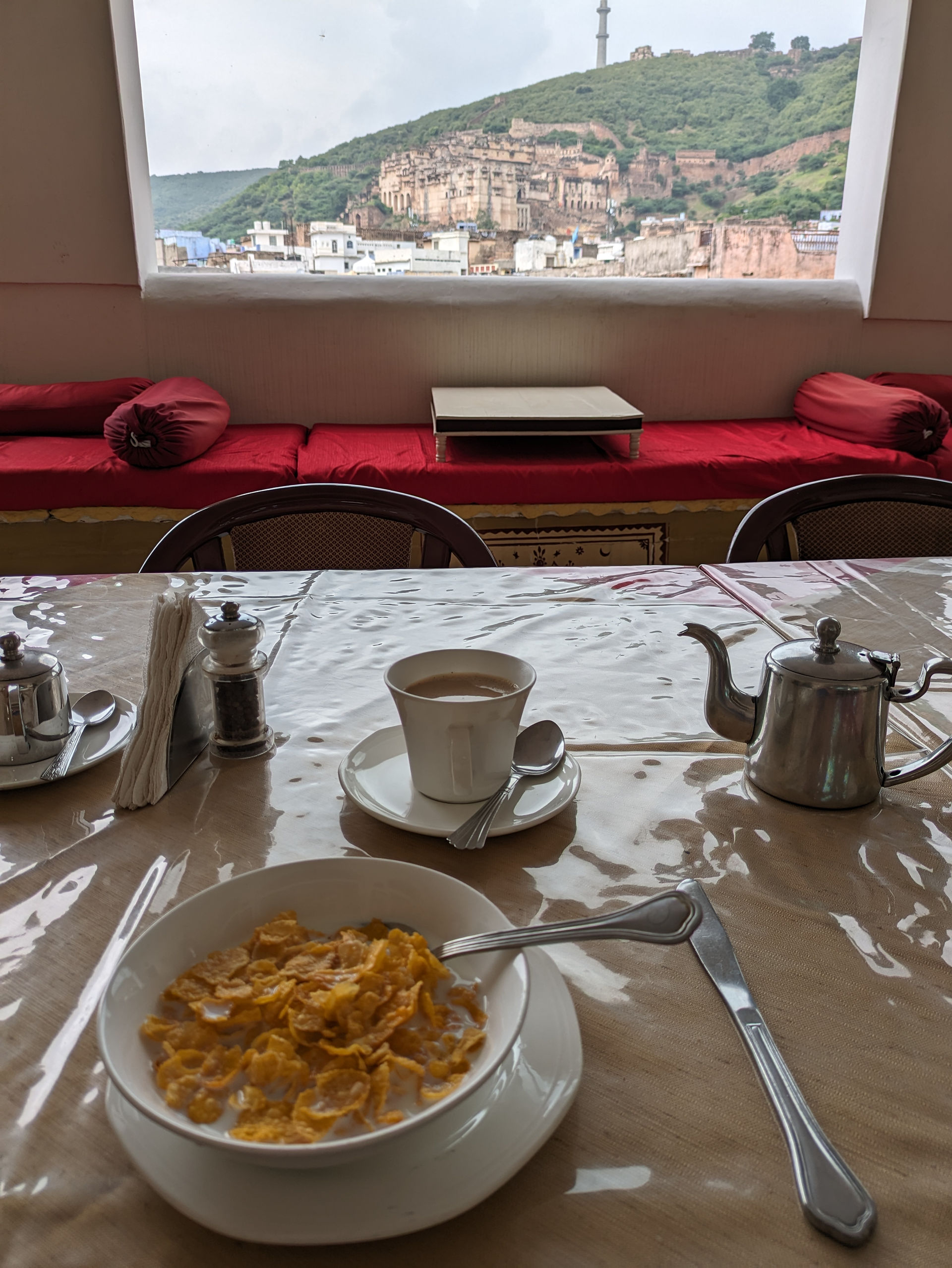 Dev Niwas hotel, Bundi. Table set for breakfast on a hotel roof terrace with the Garh Palace in the background, making this hotel a lovely stop on your Rajasthan travels