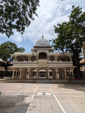 City Palace courtyard, with airy pavillion and beautiful trees, making it one of the attractions you should visit in Udaipur, India
