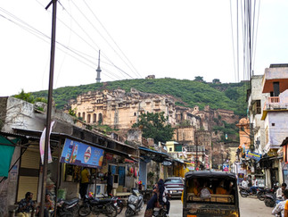 Bundi. Bustling street scene with the Garh Palace in the background on a hillside, making it one of the attractions you should visit in Bundi, India