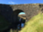 Old stone bridge straddling a shallow stream making the Fairy Bridge one of the best things to see and do in Skye