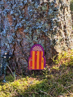 A tree trunk with a small door making this a perfect place to find the enchanted fairies of Scotland