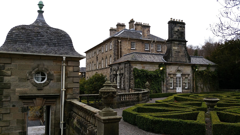 Stone mansion with slate roof, surrounded by manicured hedges and urn planters. Overcast sky, exuding a serene, historic ambiance. Things to do in Glasgow Scotland.