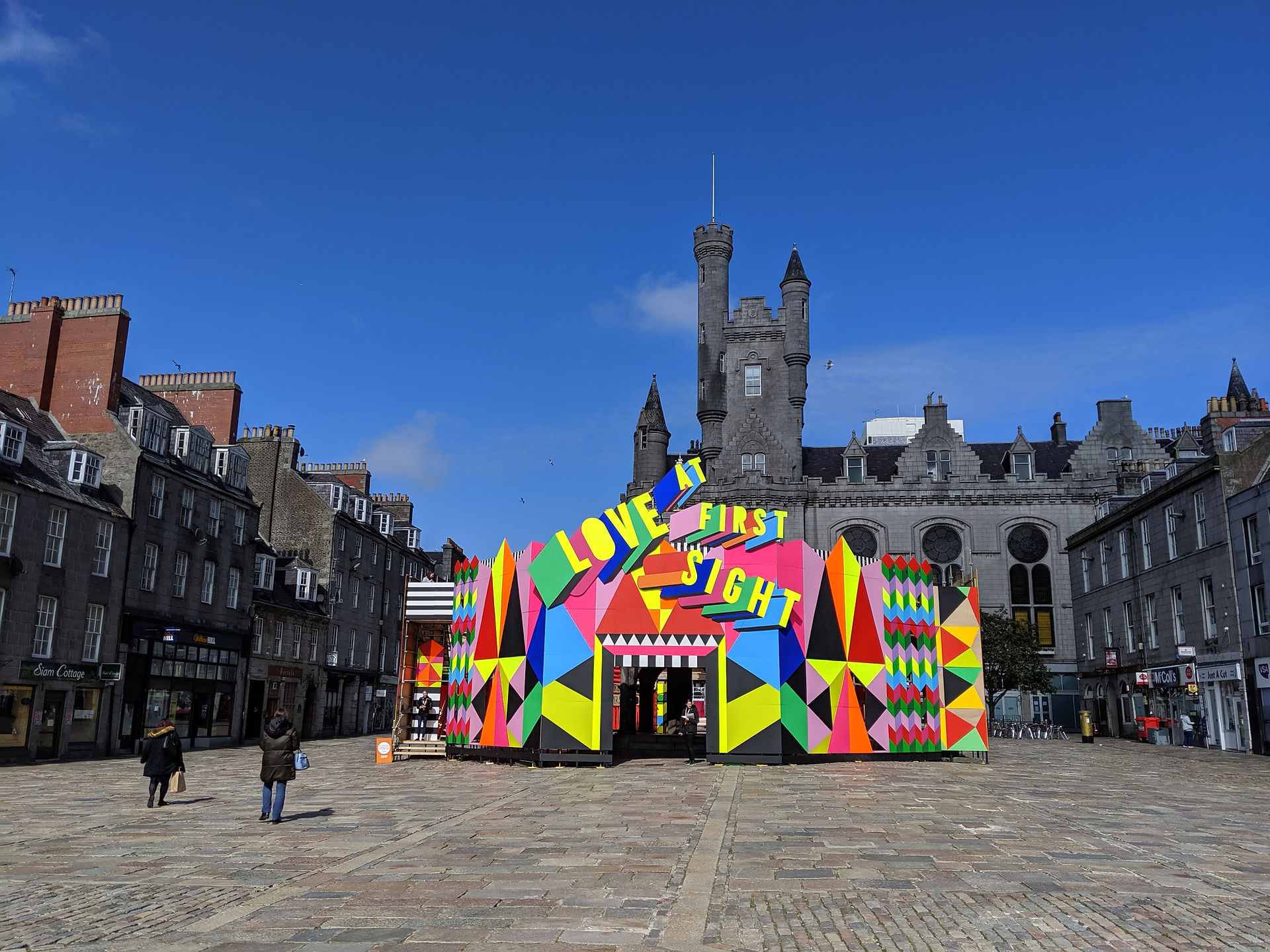 One of the Aberdeen street art murals wrapped around an historical market cross.