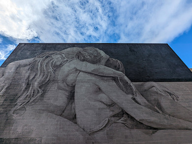 One of the Aberdeen street art murals on a building depicting two people holding each other.