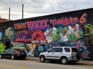 Street art murals on the side of a building depicting film references on a colourful background.