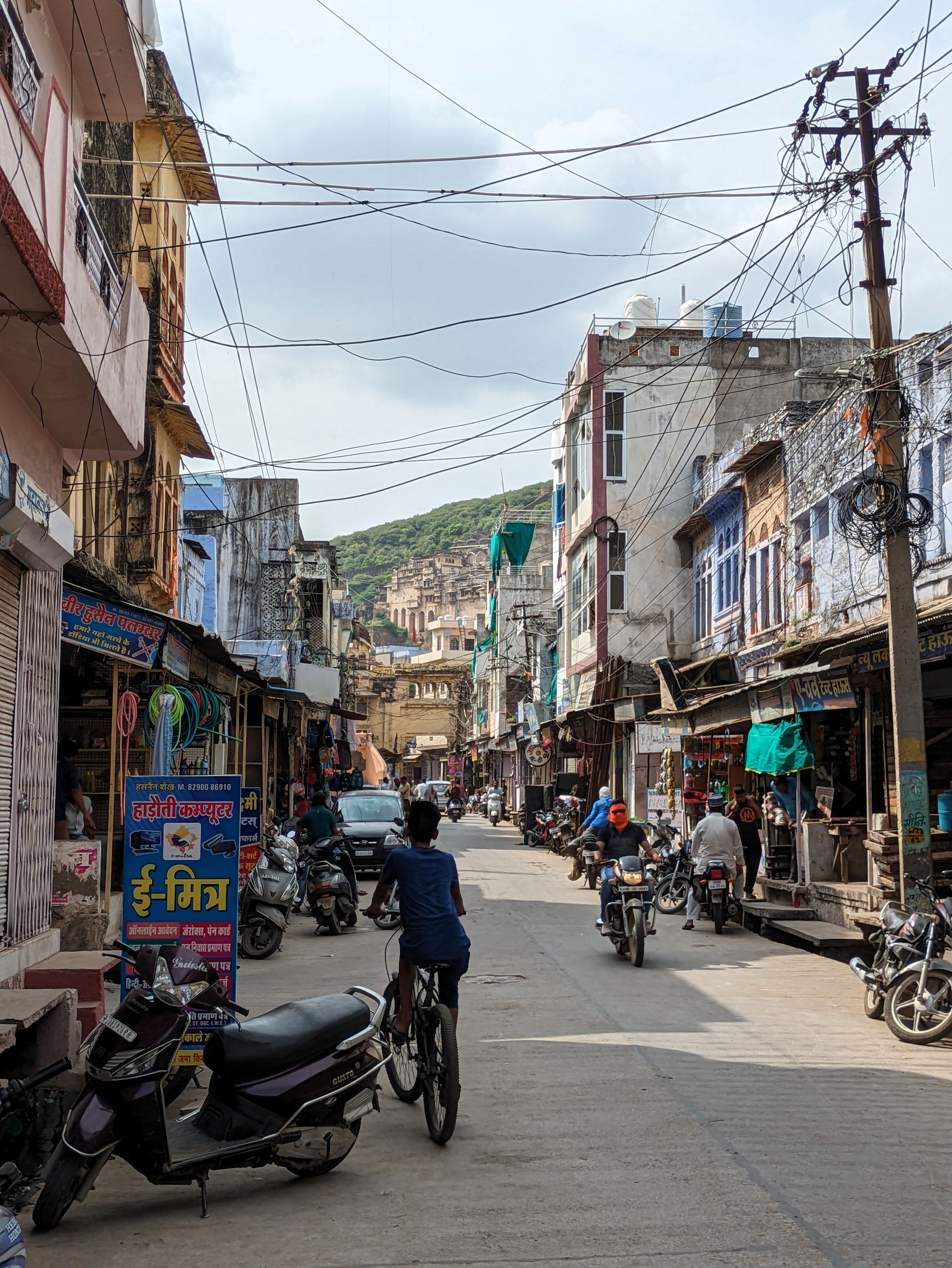 Bundi. Bustling street scene with the Garh Palace in the background, making it one of the attractions you should visit in Bundi, India