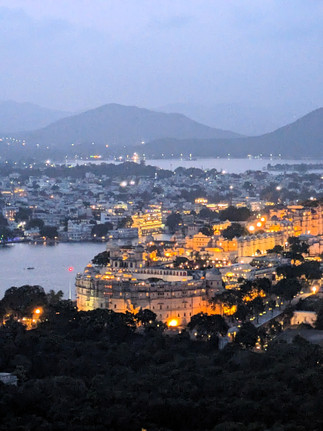 A nightime view of the City Palace from the Machhala Hill. Golden lights.making it one of the attractions you should visit in Udaipur, India