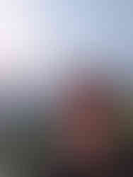 A selfie of a man taken from a hilltop, with the city of Udaipur below in the background, making it one of the attractions you should visit in Udaipur, India