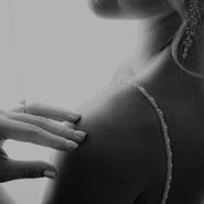 Jeune femme élégante remplissant un formulaire sur son ordinateur portable, installée dans un intérieur raffiné, baignée de lumière naturelle.