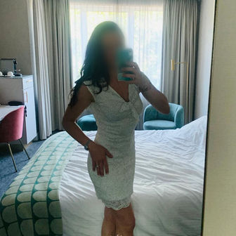 Isabeau - Authentic selfie in a fitted white dress inside a hotel suite